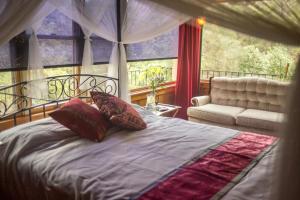 1 dormitorio con cama, sofá y ventana en Quiet Mind Lodge, Spa & Retreat Sequoias, en Kernville