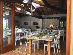 a dining room with a long table and white chairs at Semifonte Romantica in Petrognano