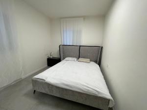 een kleine slaapkamer met een bed in een witte kamer bij SVW Apartment on the Beach in Netanya