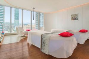 a hotel room with two beds with red pillows at W Taipei in Taipei