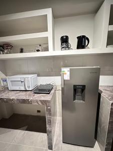 a kitchen with a counter with a refrigerator at Departamento Amoblado in Huánuco