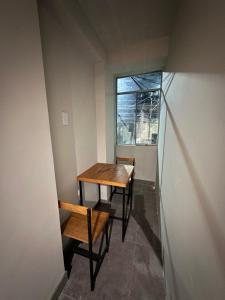 a table and chairs in a room with a window at Departamento Amoblado in Huánuco