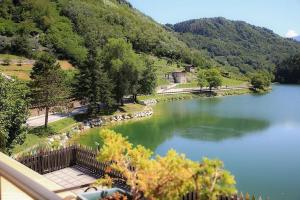 Canzolino的住宿－Albergo Aurora，享有树木繁茂的湖泊和山脉的美景