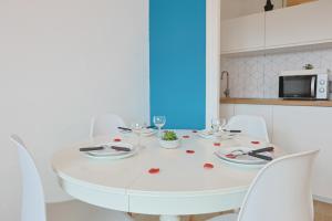 a white dining room table with white chairs at Évasion Pro & Fun à Saint-Étienne - Proche HPL in Saint-Étienne +2 photos