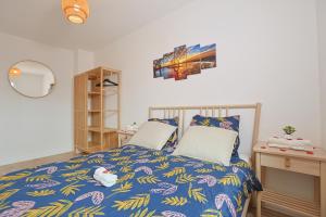 - une chambre avec un lit et une couette bleue dans l'établissement Évasion Pro & Fun à Saint-Étienne - Proche HPL, à Saint-Étienne