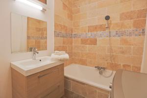 La salle de bains est pourvue d'un lavabo, d'une baignoire et de toilettes. dans l'établissement Évasion Pro & Fun à Saint-Étienne - Proche HPL, à Saint-Étienne