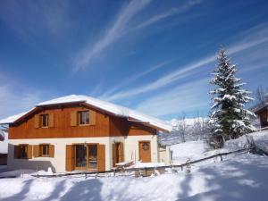 a house in the snow with a christmas tree at Chalet Bellevue in Les Orres