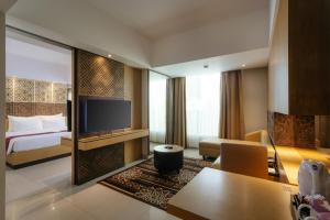 a hotel room with a bed and a television at Horison Ultima Seminyak Bali - CHSE Certified in Seminyak