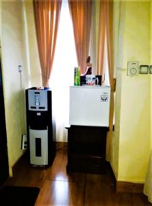 Una habitación con un pequeño refrigerador frente a una ventana. en Merta House Jasan Village, en Tegalalang