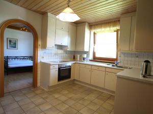 a kitchen with white cabinets and a sink and a window at Cozy Apartment in Ruhmannsfelden with Swimming pool in Achslach