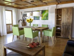 une salle à manger avec une table et des chaises vertes dans l'établissement Cozy Apartment in Ruhmannsfelden with Swimming pool, à Achslach