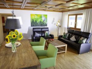 - un salon avec un vase de tournesols sur une table dans l'établissement Cozy Apartment in Ruhmannsfelden with Swimming pool, à Achslach