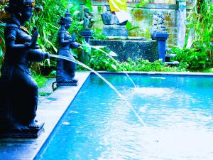 Dos estatuas están rociando agua desde una fuente. en Merta House Jasan Village, en Tegalalang