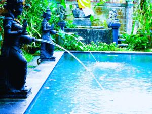 Dos estatuas rocían agua de una fuente. en Merta House Jasan Village, en Tegalalang