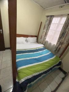 Cama pequeña en habitación con ventana en Drish Haven en Nairobi