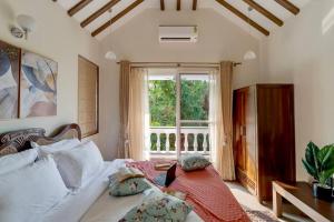 Villa Hestia-3bed villa in Assagao By Masaya Stays في Verla: غرفة نوم بسرير ونافذة