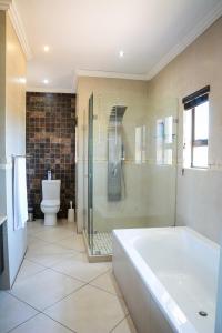 a bathroom with a tub and a shower and a toilet at 2916 on Egret - Parys Country and Golf Estate - Loadshedding friendly in Parys