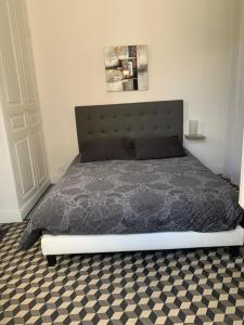 a bed in a bedroom with a checkered floor at Chez Chris in Cour-Cheverny