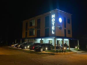 un hôtel avec des voitures garées dans un parking la nuit dans l'établissement Hotel ZT, à Mariquita
