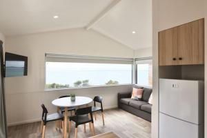 a kitchen and living room with a table and a couch at Sea Vu Caravan Park in Robe