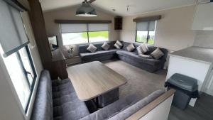 a living room with a couch and a table at 238 Arran View, Craig Tara Holiday Park in Ayr