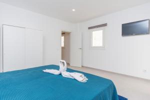 a white room with a bed with a stuffed animal on it at Aroa 1 in Cala Ratjada