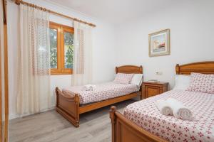 a bedroom with two beds and a window at Villa Canta in Playa de Muro