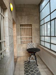 a table and a chair sitting in a room at Baka Bauhaus Studio in Jerusalem