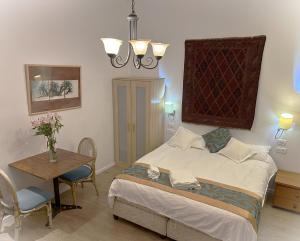 1 dormitorio con 1 cama, mesa y sillas en Baka Bauhaus Studio, en Jerusalén
