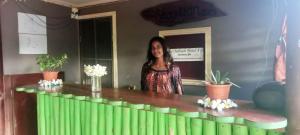Outback Retreat/Hotel, Ba Fiji في Tonge: امرأة تقف بجانب كونتر به نباتات