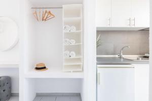 a kitchen with white cabinets and a sink at Valasi Studios in Skála Foúrkas +38 photos