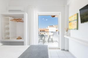 a white room with a view of a balcony at Valasi Studios in Skála Foúrkas