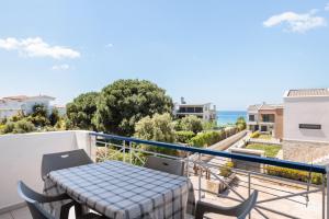 a table and chairs on a balcony with a view of the ocean at Valasi Studios in Skála Foúrkas