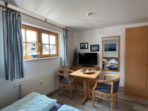 a room with a table and chairs and a bedroom at Höfthus 8 in Alt Reddevitz