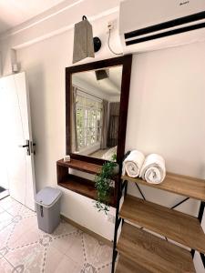 een badkamer met een spiegel aan de muur bij Twin Palms Surfhouse in Thulusdhoo