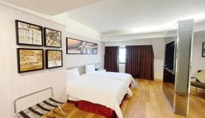 a hotel room with two beds and a tv at Delton Hotel in Kaohsiung