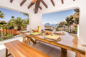 a dining room with a table and a large window at Casa Buena Vista in Teulada