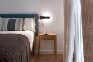 Un dormitorio con una cama y una mesa con una taza. en Magno Apartments Sepúlveda en Sevilla