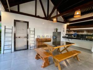 a kitchen with a table and benches in a room at Casa De Rosa in Dipolog
