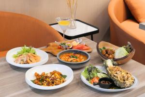 un tavolo con quattro piatti di cibo sopra di PARKROYAL Suites Bangkok - SHA Plus Certified a Bangkok
