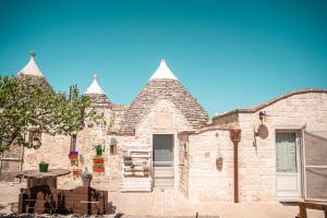 an old stone building with a table in front of it at Trulli Beauty Romantic ALCOVA con piscina in Locorotondo