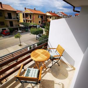 a balcony with two chairs and a wooden table and a table at CASA BLANCA in Umag