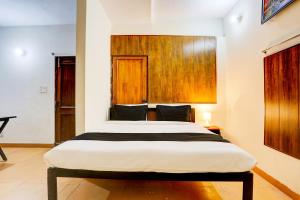 um quarto com uma cama grande num quarto em OYO KC Hotels em Nova Deli