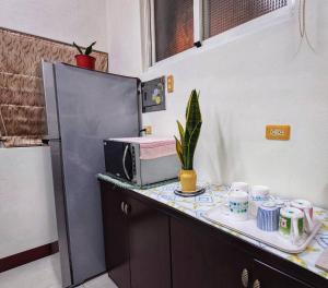 a kitchen with a counter with a microwave and cups at Alley B&B in Magong