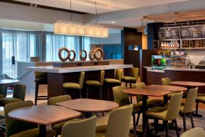 a restaurant with tables and chairs and a bar at Courtyard by Marriott Norwalk in Norwalk