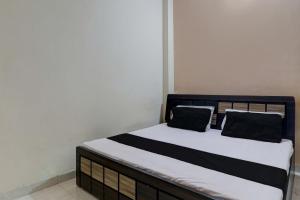 a bed with black and white sheets and pillows at OYO Shine Hotel in Lucknow