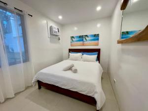ein kleines Schlafzimmer mit einem Bett mit weißer Bettwäsche in der Unterkunft Casa De Rosa in Dipolog City