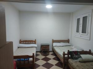 two beds in a room with a checkered floor at Beachfront Villa 3bedrooms+3bathrooms in El Alamein