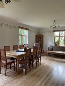 a dining room with a wooden table and chairs at Mazelejas muižiņa in Vircava