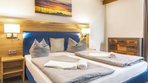 een slaapkamer met 2 bedden en handdoeken bij Hotel Casa Maria in Halblech
